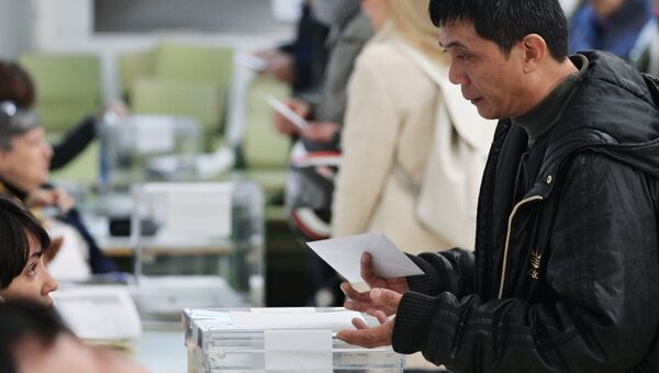 Мужчина во время голосования на избирательном участке на внеочередных выборах в парламент Каталонии. 21 декабря 2017