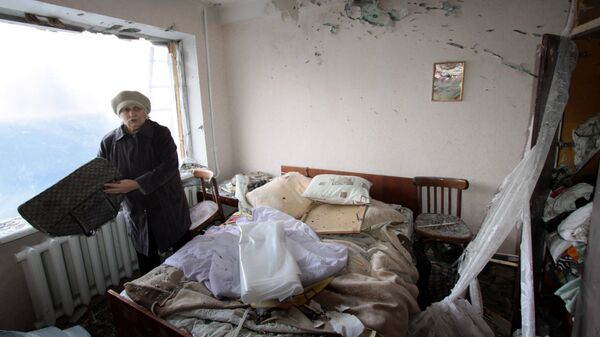 Женщина в комнате жилого дома в городе Ясиноватая, пострадавшего в результате обстрела