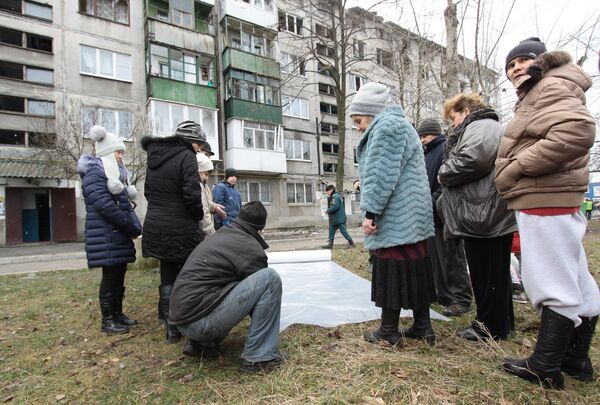 Жителям домов города Ясиноватая, пострадавшим в результате обстрела, выдают пленку, чтобы закрыть разбитые окна. 21 декабря 2017