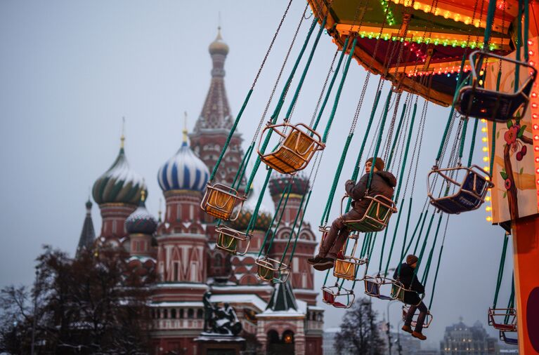 Дети катаются на карусели на Красной площади в Москве