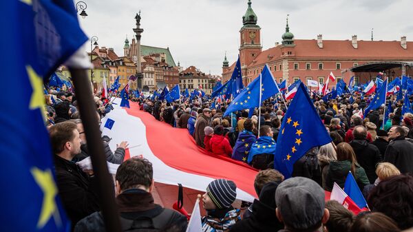 Люди с флагами Польши и ЕС в Варшаве