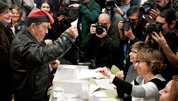 Мужчина голосует на избирательном участке на внеочередных выборах в парламент Каталонии