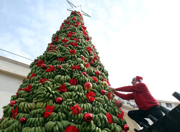 Человек украшает елку из бананов в Дамуре, Ливан