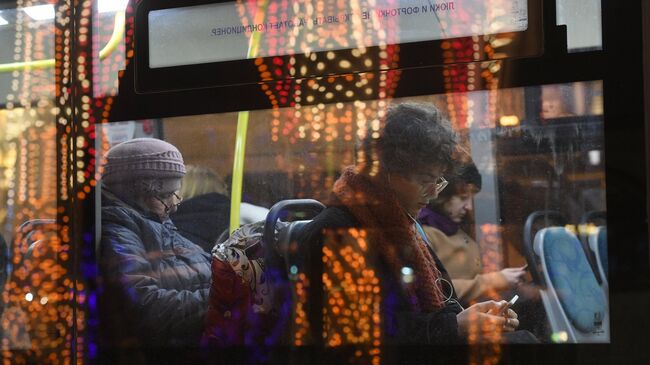 Пассажиры в салоне автобуса, проезжающего мимо Театральной площади в Москве. Архивное фото