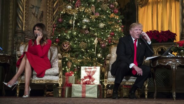 Президент США Дональд Трамп и первая леди Мелания Трамп говорят поздравляют детей по телефону во время рождественской акции в поместье президента Мар-а-Лаго в Палм-Бич, штат Флорида. 24 декабря 2017