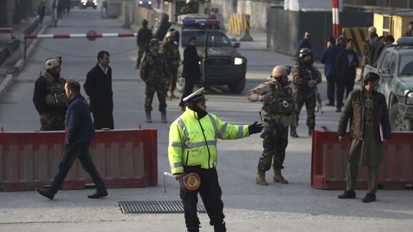 Афганская дорожная полиция и сотрудники службы безопасности работают возле места подрыва самоубийцы в Кабуле. 25 декабря 2017