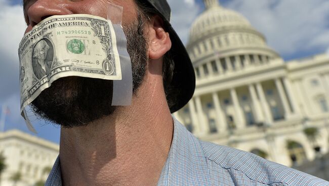 Мужчина с заклеенным долларовой купюрой ртом перед зданием Капитолия в Вашингтоне. Архивное фото