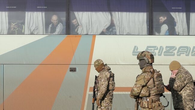 Украинские военные рядом с автобусом, перевозящим военнопленных ДНР и ЛНР к месту обмена