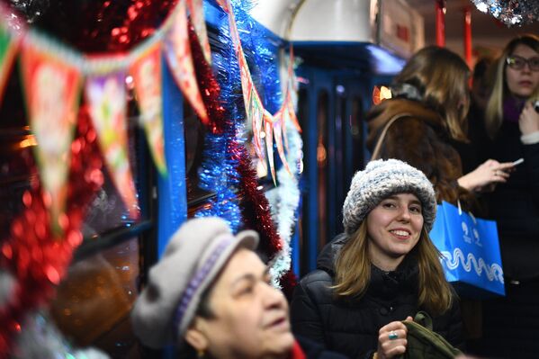 Пассажиры в салоне новогоднего трамвая в Москве