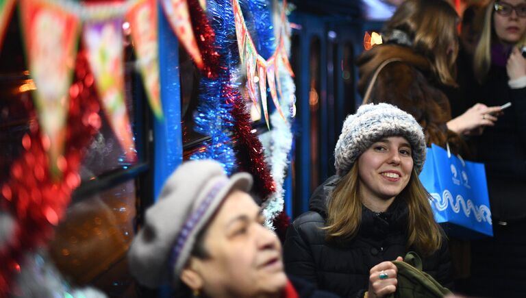 Пассажиры в салоне новогоднего трамвая в Москве