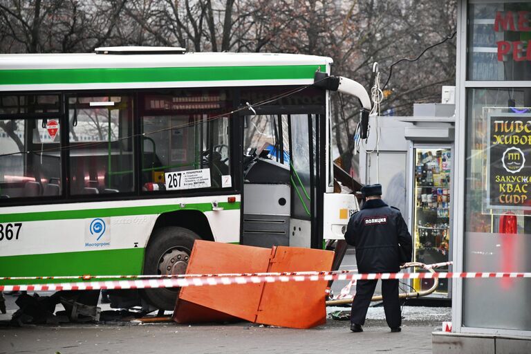 Сотрудник правоохранительных органов у пассажирского автобуса, въехавшего в остановку на Сходненской улице в Москве. 29 декабря 2017