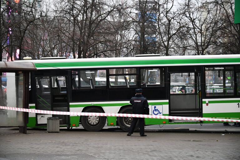 Сотрудник правоохранительных органов у пассажирского автобуса, въехавшего в остановку на Сходненской улице в Москве. 29 декабря 2017