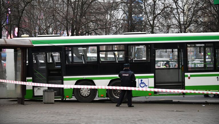 Сотрудник правоохранительных органов у пассажирского автобуса, въехавшего в остановку на Сходненской улице в Москве. 29 декабря 2017