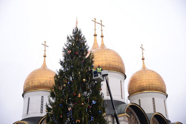 Рабочие украшают новогоднюю елку на Соборной площади Кремля
