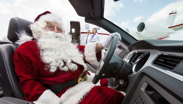 Мужчина в костюме Деда Мороза за рулем автомобиля