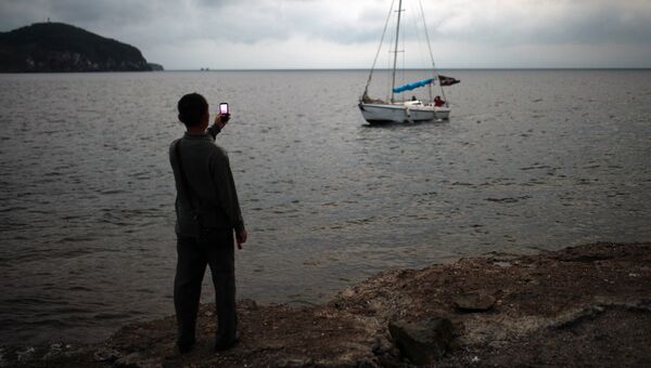 Мальчик фотографирует яхту во Владивостоке