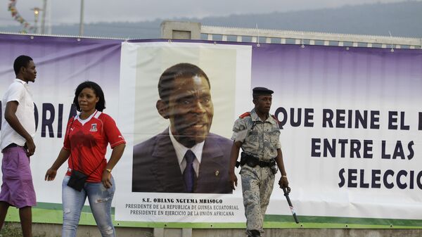 Сотрудник службы безопасности рядоом с портретом президента Экваториальной Гвинеи Теодоро Обианги Нгемы Мбасого. Архивное фото