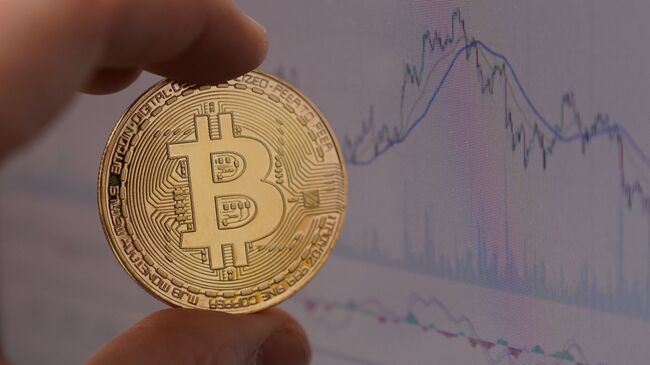 Монета с логотипом криптовалюты биткоин. Архивное фото