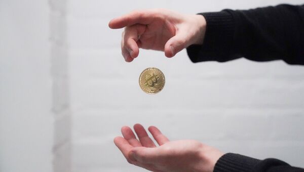 Сувенирная монета с логотипом криптовалюты биткоин. Архивное фото