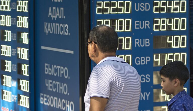 Мужчина у информационного табло обменного пункта валюты в Алма-Ате. 2015 год Мужчина у информационного табло обменного пункта валюты в Алма-Ате. 2015 год