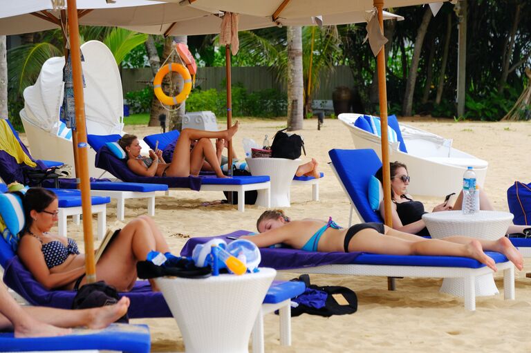 Туристы отдыхают на пляже Таиланда Туристы отдыхают на пляже Таиланда