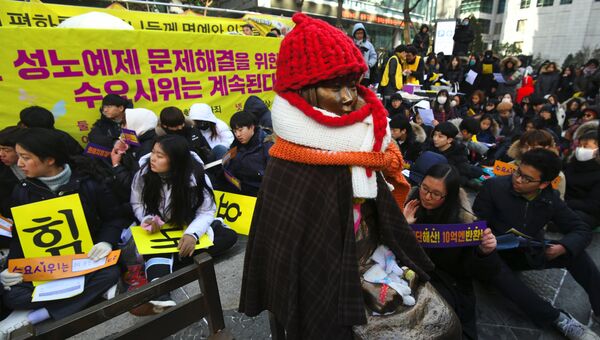 Протестующие рядом со статуей  южнокорейской девушки, символизирующей, так называемых, «женщин для утешения», которые служили секс-рабынями для японских солдат во время Второй мировой войны. 10 янвваря 2018