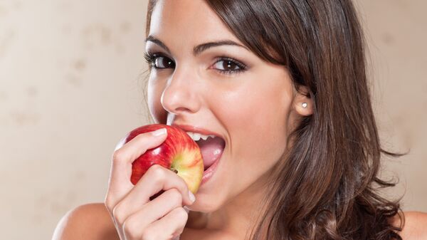 Девушка ест яблоко