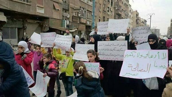 Жители поселений, захваченных боевиками в восточном пригороде Дамаска, во время акции протеста против присутствия вооруженных группировок