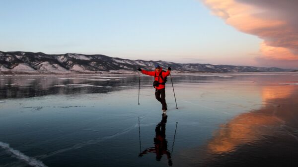 Мужчина на коньках на льду озера Байкал