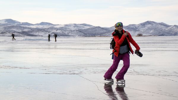 Девушка на коньках на льду озера Байкал