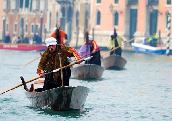 Мужчины в костюме Бефаны плывут по Гранд-каналу в Крещенский сочельник в Венеции