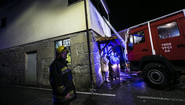 Пожарные у здания местного общинного центра, где во время пожара погибло восемь человек в Вила-Нова-да-Рейнха в Тонделе, Португалия. 13 января 2018