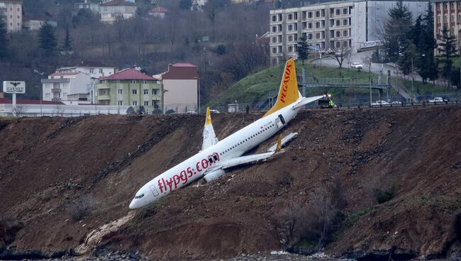 Пассажирский самолет Pegasus Airlines Boeing 737 на набережной, куда он выкатился со взлетно-посадочной полосы, после посадки в аэропорту Трабзона на побережье Черного моря. 14 января 2018