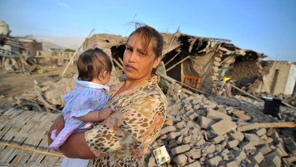 Женщина перед домом. поврежденным землетрясением силой 7,1 баллов, поразившем побережье южного Перу. 14 января 2018