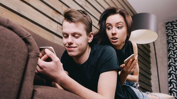 Молодая пара с мобильными устройствами