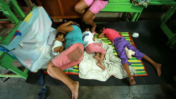Филиппинцы спят во временном убежище после эвакуации из своих домов из-за извержения вулкана Майон в городе Камалиг, провинция Албай. 15 января 2018 года