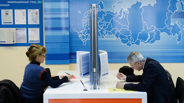 Посетители заполняют документы в инспекции Федеральной налоговой службы РФ