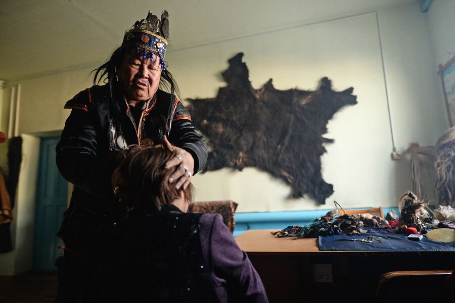 Председатель шаманского общества Адыг-Ээрен (Дух медведя), верховный шаман Республики Тыва Допчун-Оол Кара-оол Тюлюшевич проводит обряд с посетителем в своей комнате в доме, который занимает шаманское общество в Кызыле