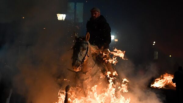 Всадник прыгает через костер во время огненного фестиваля Las Luminarias в Испании