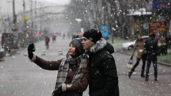 Молодые люди во время снегопада в Киеве 