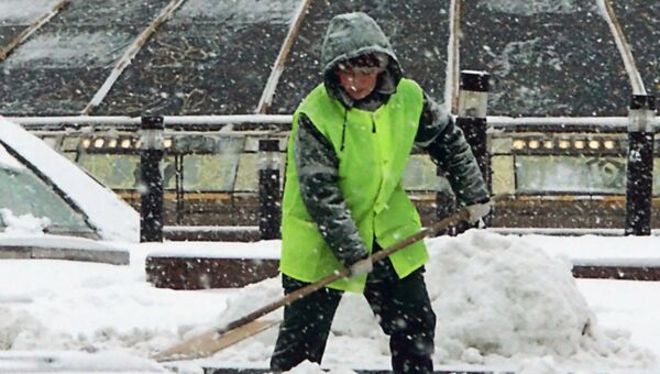 Работник городской коммунальной службы убирает снег на Манежной площади в Москве. Архивное фото