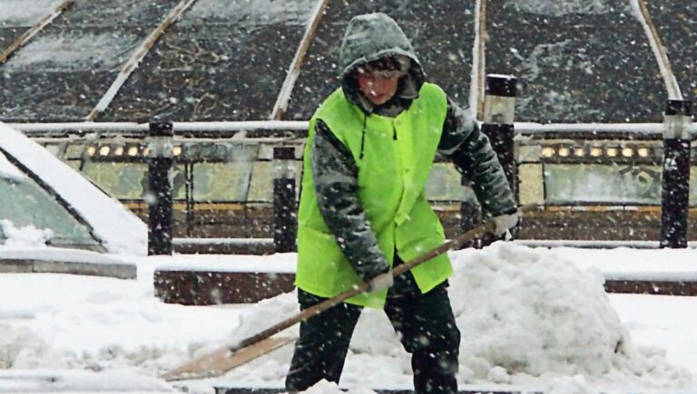 Работник городской коммунальной службы убирает снег на Манежной площади в Москве