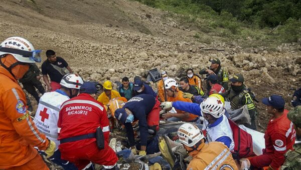 Спасатели ищут тела пассажиров автобуса, который попал под оползень на дороге между Хунина и Тукерреса в Колумбии. 21 января 2018
