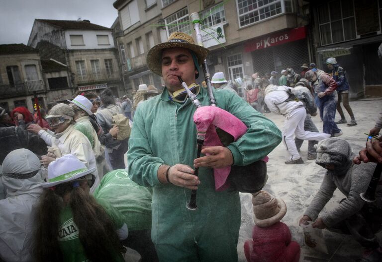 Мужчина играет на волынке во время мучного фестиваля Domingo Fareleiro в Испании