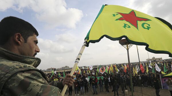 Член сил самообороны сирийских курдов (YPG) во время демонстрации в городе Амуда в Сирии