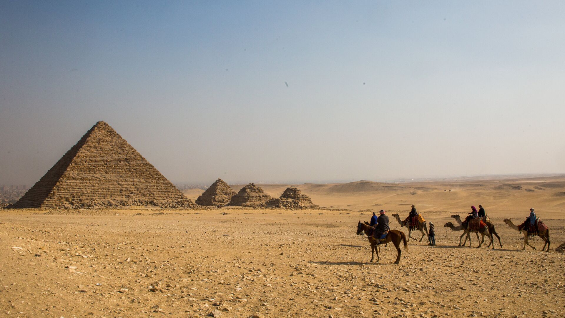 Группа туристов верхом на лошадях и верблюдах во время экскурсии к древнеегипетским пирамидам в Эль-Гизе, пригороде Каира. Слева: пирамида Микерина (Менкаура) - РИА Новости, 1920, 10.09.2020