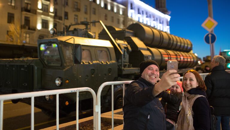 Прохожие фотографируются на фоне зенитной ракетной системы С-400 Триумф во время прохода военной техники по Тверской улице перед репетицией парада Победы на Красной площади
