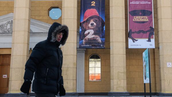 Афиши фильмов Приключения Паддингтона-2 и Смерть Сталина на фасаде кинотеатра Победа в Новосибирске
