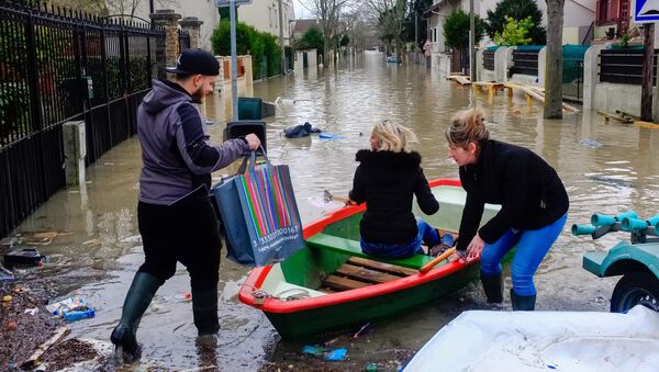 Местные жители переправляются на лодке на одной из затопленной улице в Париже, из-за прошедших ливневых дождей