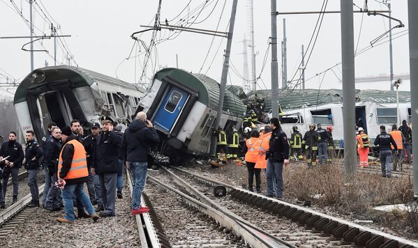Спасатели и полицейские на месте крушения поезда на окраине Милана, Италия. 25 января 2018 года
